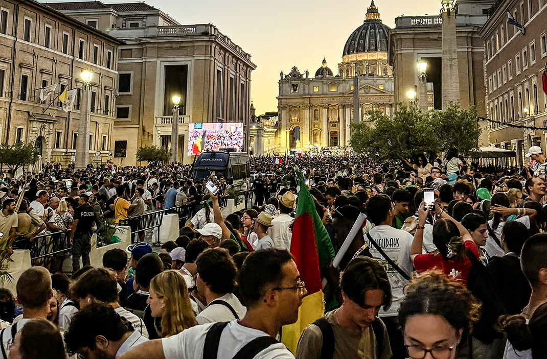 Menschenmenge bei Abendveranstaltung auf der Via della Conciliazione in Rom mit Blick auf den Petersdom